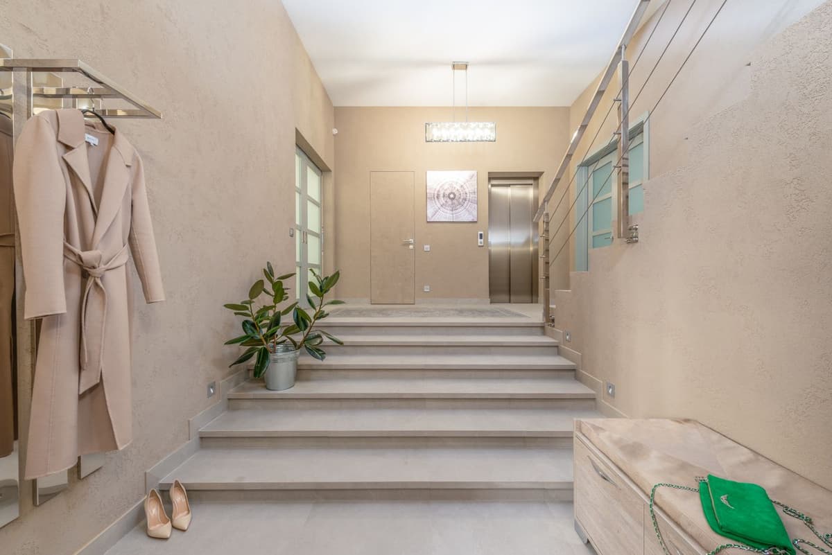 Hall d'immeuble clair avec escalier et ascenseur