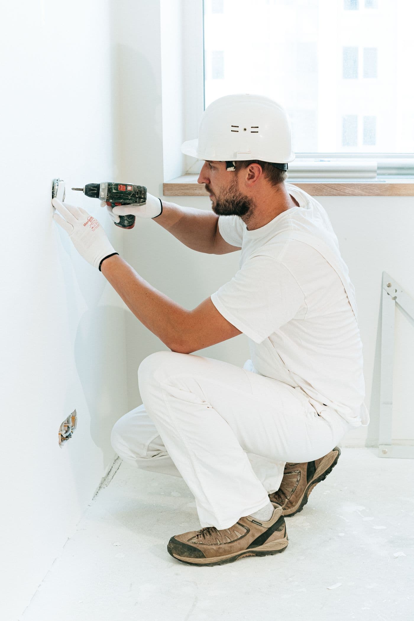Intervention électrique : perçage du mur près d'une prise